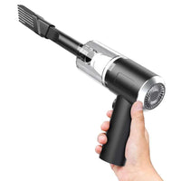 Handheld vacuum cleaner with attachments held by a hand on a white background