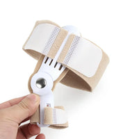 A beige and white adjustable wrist support brace being held by a hand against a plain white background.