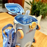 Children's water bottle with straw on a wooden surface