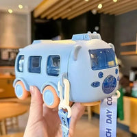 Toy bus held by a hand with a blurred indoor background