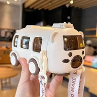 White toy bus with black windows held by a hand in an indoor setting