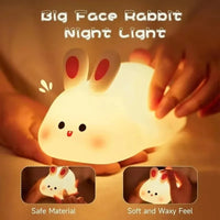 Cute rabbit silicone night light glowing softly on a bedside table in a kids nursery