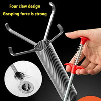Hand holding a metal tool with red handle, designed to remove hair from drains, on a black background.
