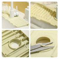 Scissors adjusting the center hole aperture of the flexible silicone tray to fit a large faucet base
