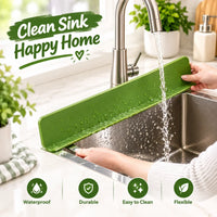 Muveszi green silicone kitchen faucet splash guard mat installed over a stainless steel sink.