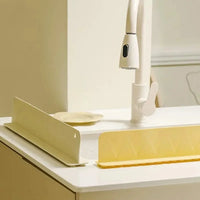 Washing sponge and liquid dish soap bottle placed neatly on top of the silicone faucet splash guard