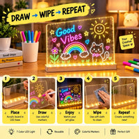 A glowing acrylic LED art board on a desk with a cat, rainbow, sun, and the words 'Good Vibes' in neon-style colors. The scene includes a hand wiping the board with a cloth, colored markers in cups, books, and a step-by-step usage graphic at the bottom explaining how to draw, wipe, and repeat.