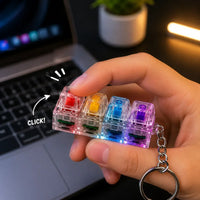 Finger pressing a colorful key on the mechanical keyboard switch keychain showing tactile action