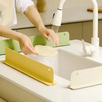 Water automatically flowing down the drainage slope of the silicone sink mat into the basin