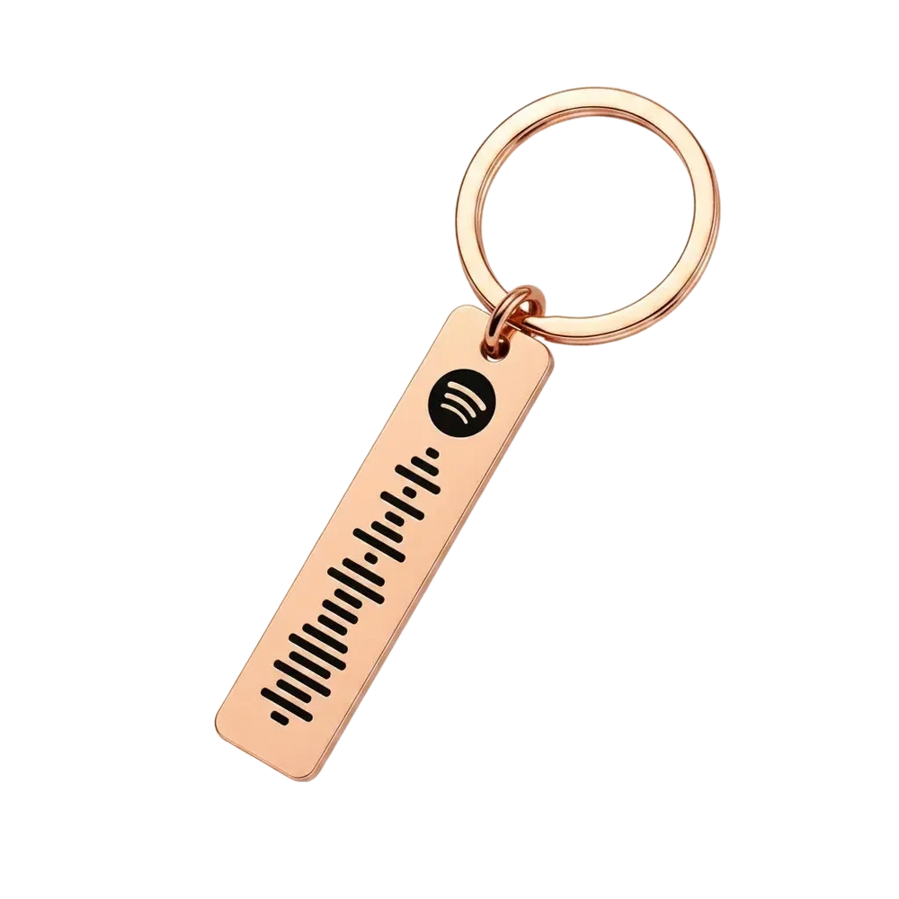A rose gold keychain featuring a rectangular bar engraved with a Spotify logo and sound wave, attached to a split key ring on a solid white background.